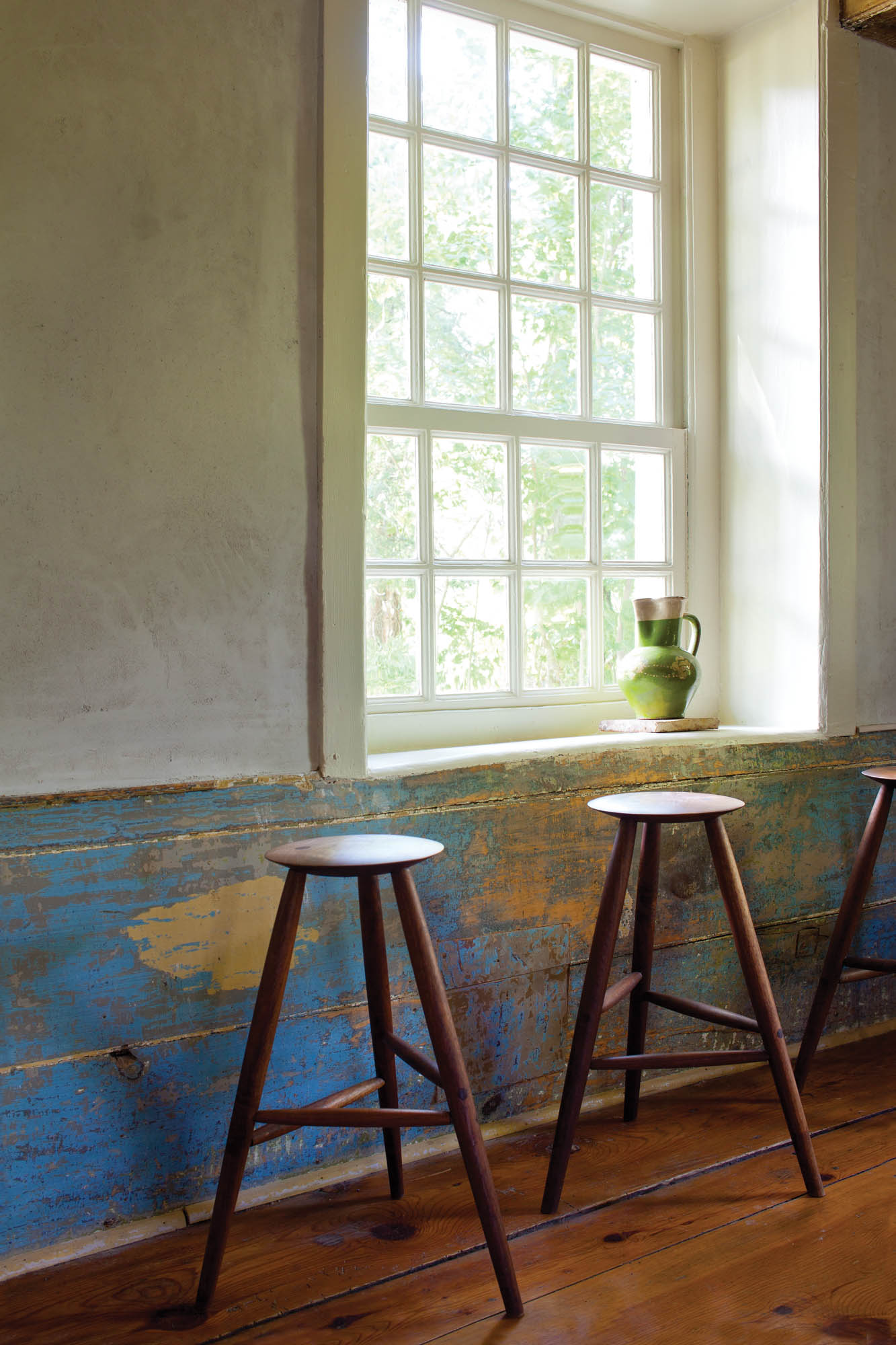 Photo of wooden stools in front of a window.
